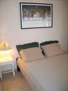 ein Schlafzimmer mit einem Bett mit einer Lampe und einem Bild an der Wand in der Unterkunft The Provence Villa in Entrecasteaux
