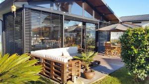 a patio with a chair and an umbrella at Casa dos Amigos - A luxury home in the nature in Torreira