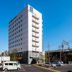 uma carrinha branca estacionada num parque de estacionamento em frente a um edifício em Super Hotel Premier Musashi Kosugi Ekimae em Kawasaki