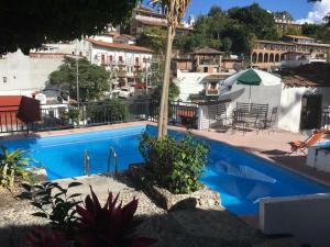 a blue swimming pool with a view of a city at Hotel Real de San Diego in Taxco de Alarcón