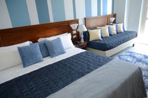 a bedroom with two beds with blue and white pillows at Hotel Giulio Cesare in Turin