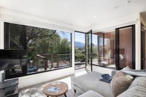 a living room with a couch and a large window at Brooklands Apartments in Healesville