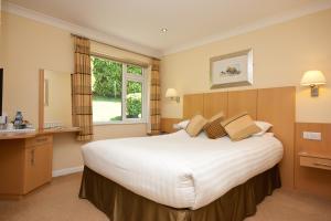 a hotel room with a large bed and a sink at Lingwood Lodge in Bowness-on-Windermere