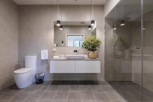 a bathroom with a toilet, sink and tub at Brooklands Apartments in Healesville