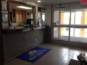 un vestíbulo de oficina con recepción y una alfombra azul de bienvenida en Americas Best Value Inn and Suites Sidney, en Sidney