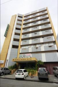 un grande edificio con macchine parcheggiate di fronte di Manila Manor Hotel a Manila