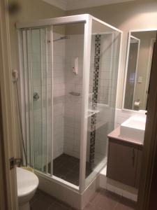 a bathroom with a shower, sink, and toilet at Breakwater Short Stay in Mandurah