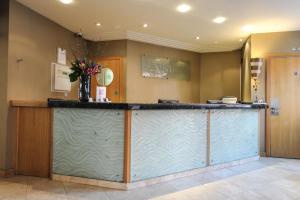 a kitchen with a large counter top and a large window at The Pinewood Hotel in Slough
