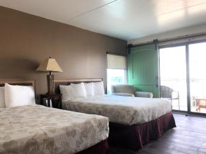 een hotelkamer met 2 bedden en een raam bij Ala Moana Motel & Suites in Wildwood
