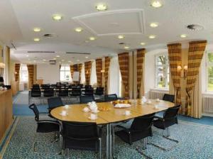 una sala de conferencias con una gran mesa de madera y sillas en Schloss Neutrauchburg en Isny im Allgäu