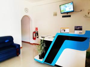 a room with a desk and a tv on a wall at Rajarata Family Resort in Anuradhapura