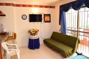 a living room with a couch and a tv at APARTAMENTO EDIFICIO LOS LAURELES in Santa Marta