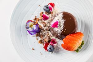 a white plate with a dessert with chocolate and fruit at Peppers Blue on Blue in Nelly Bay
