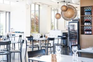 a restaurant with tables and chairs and windows at Peppers Blue on Blue in Nelly Bay