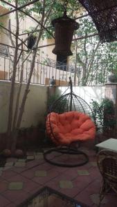 a red chair sitting on a patio at Fifth Settlement Apartment in Cairo