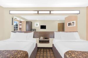 Microtel Inn & Suites by Wyndham Franklin في فرانكلين: غرفة فندقية بسريرين وتلفزيون