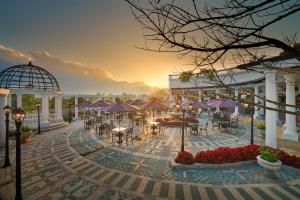 un patio con mesas y sombrillas en Silk Path Grand Sapa Resort & Spa, en Sa Pa