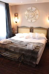 a hotel room with a large bed with white pillows at Hôtel du Romancier in Paris