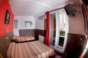 a small room with two beds and a window at Be Ramblas Guest House in Barcelona +24 photos