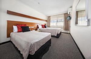 ein Hotelzimmer mit 2 Betten und einem Fenster in der Unterkunft Belconnen Way Hotel & Serviced Apartments in Canberra