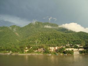 a town on the shore of a river with a mountain at Sanidhya Inn in Rishīkesh +12 photos