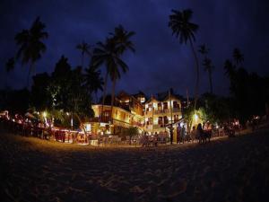 a group of people standing on a beach at night at The Villa Hotel in Unawatuna
