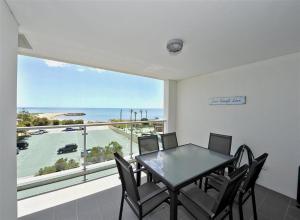 a dining room with a table and chairs and a large window at Mandurah Magic Penthouse. in Mandurah