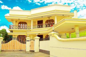 a yellow house with a balcony on top of it at Metropolitan Serviced Villa in Cochin