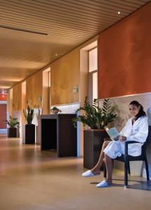 a woman sitting in a chair with a laptop at Atlantic Terme Natural Spa & Hotel in Abano Terme +90 photos