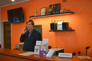 una mujer hablando en un celular en un escritorio en Jeruzale Hotel en Vilna