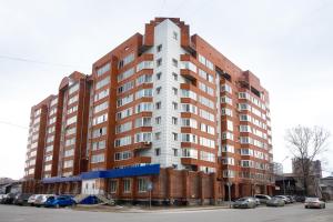 トムスクにあるKvartiry na Rozy Liuksiemburghの駐車場に車を停めた高層ビル