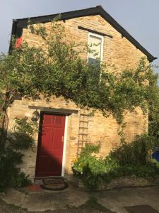 ein Backsteinhaus mit einer roten Tür und einem Fenster in der Unterkunft The Annexe Croughton in Banbury