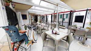 a bike parked in a restaurant with tables and chairs at Residence Colibrì Family & Bike in Loano