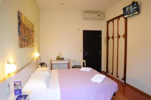 a bedroom with a white bed with two white pillows at Hotel dell'Amarissimo in Bellaria-Igea Marina +24 photos