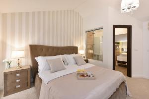a bedroom with a bed with a tray of food on it at Harvey's luxury rooms in Zadar