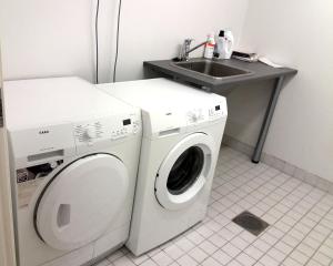 y baño con lavadora y lavamanos. en LeviBooking LeviStar II apt 309 en Levi