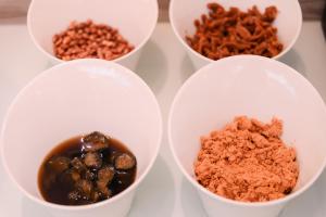 four white cups filled with different types of food at Cai-Lai Motel in Yangmei