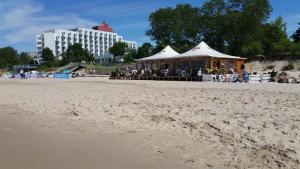a tent on the beach with a group of people at Apartament Andreas in Międzyzdroje