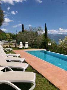 un gruppo di sedie a sdraio accanto alla piscina di Caselli Vigole al Sole a Toscolano Maderno