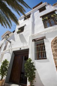 biały budynek z drzwiami i palmą w obiekcie Casa de Pueblo "Casa Madeli" w mieście Chulilla