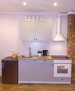 una cucina con armadi bianchi e lavandino di Suur-Ameerika Apartment a Tallinn