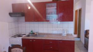 a kitchen with red cabinets and a sink and a stove at Lubin in Sevid
