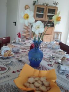 stół z niebieską wazą z kwiatami w obiekcie B&B RAINA w mieście Castelfondo