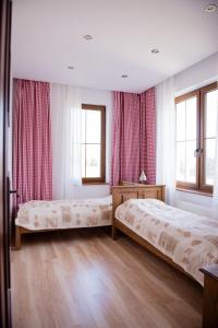 um quarto com 2 camas e 2 janelas em Lipowy Dwór em Szczecinek