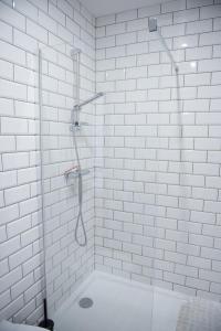 a white bathroom with a shower with a glass door at Lipowy Dwór in Szczecinek