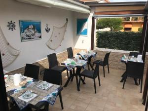 - un restaurant avec des tables et des chaises sur la terrasse dans l'établissement La Conchiglia, à Tropea
