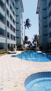 a swimming pool in front of a building at Sunny Beachfront Studio in Mombasa