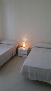 Un dormitorio con dos camas y una lámpara en una mesita de noche. en Apartamento con fantásticas vistas al mar, en Benidorm