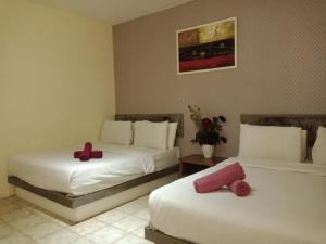 a room with two beds with crosses on them at Hotel 77 Rawang in Rawang