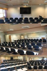 an empty lecture hall with chairs and a screen at Bardufosstun in Bardufoss